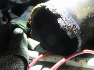 Extremo del escape con rotura y corrosión avanzada