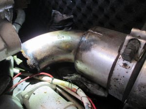 Codo de escape del motor de estribor con rotura perimetral y corrosión avanzada